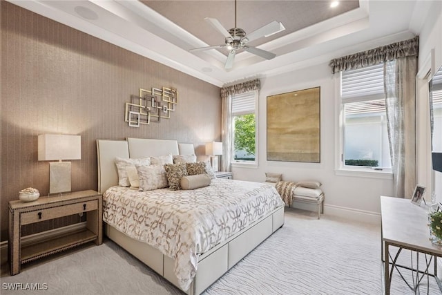 bedroom with ceiling fan, a raised ceiling, baseboards, and light carpet