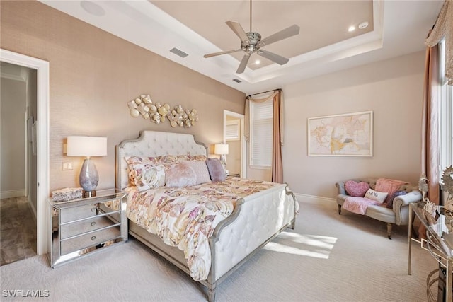 bedroom featuring visible vents, a tray ceiling, recessed lighting, carpet, and baseboards