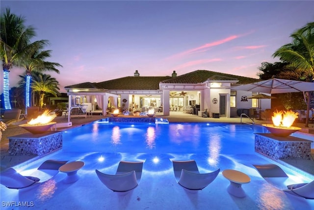 pool with ceiling fan, a patio, and an outdoor fire pit