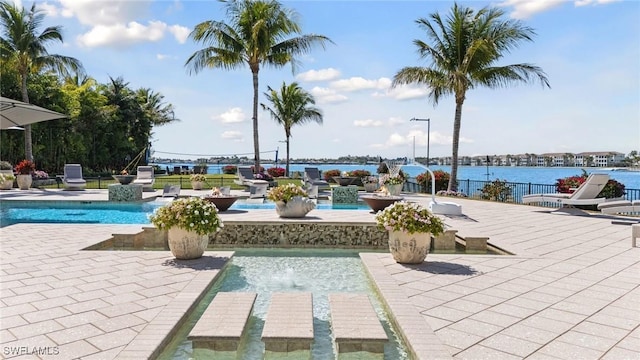 outdoor pool with a patio and a water view