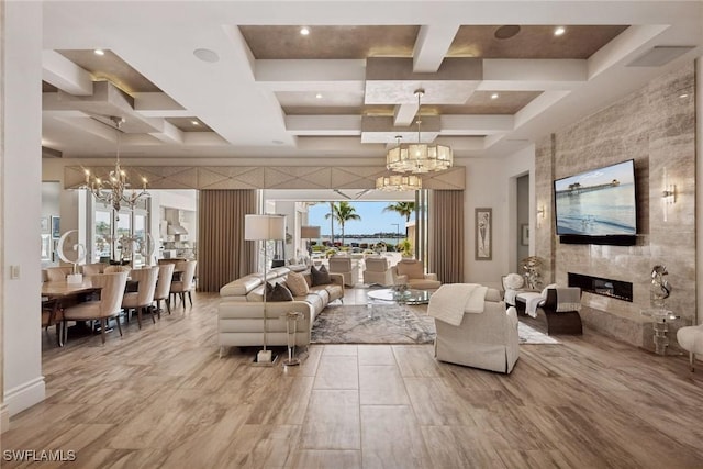 living area with a high ceiling, a fireplace, coffered ceiling, and an inviting chandelier