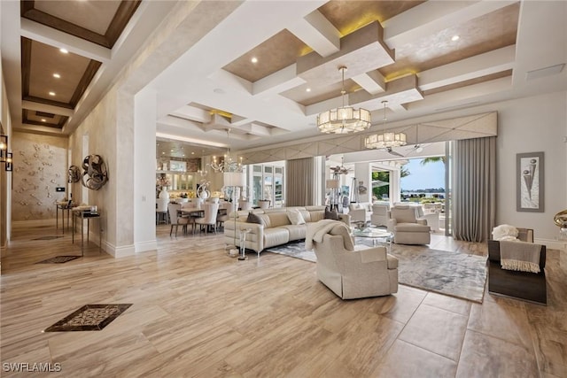 living area with baseboards, beamed ceiling, a high ceiling, an inviting chandelier, and coffered ceiling