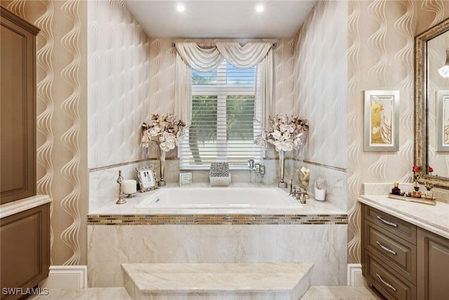 bathroom with vanity, a garden tub, and wallpapered walls