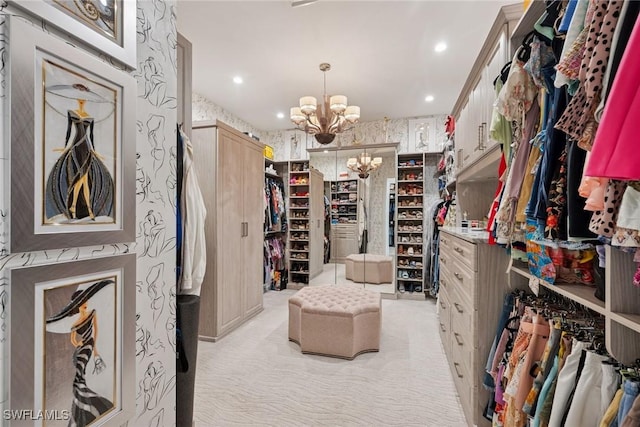 walk in closet featuring a chandelier and light colored carpet