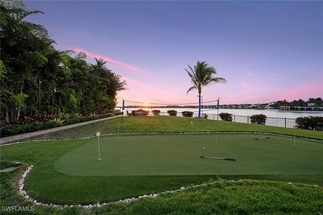 surrounding community with a lawn, fence, and a water view