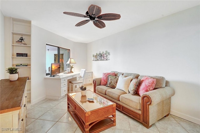 living area featuring light tile patterned floors, baseboards, and ceiling fan