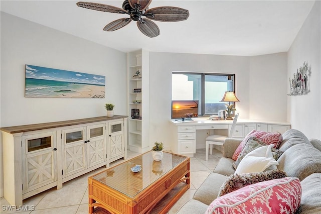 living room with light tile patterned flooring, built in desk, built in shelves, and ceiling fan