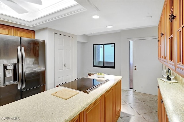 kitchen with stainless steel fridge with ice dispenser, cooktop, light countertops, recessed lighting, and light tile patterned flooring