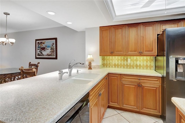 kitchen with a sink, black dishwasher, tasteful backsplash, stainless steel fridge, and light tile patterned flooring