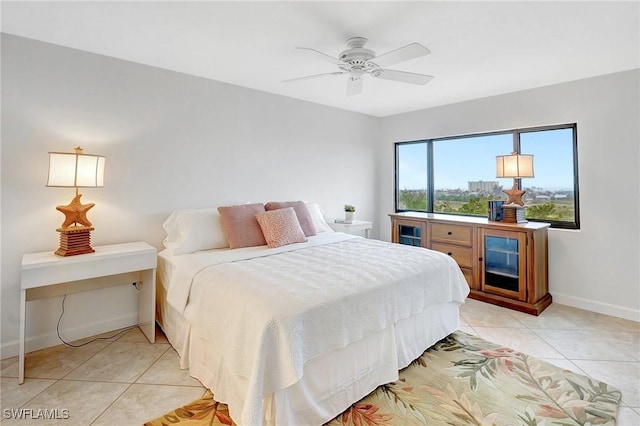 bedroom with light tile patterned floors, a ceiling fan, and baseboards