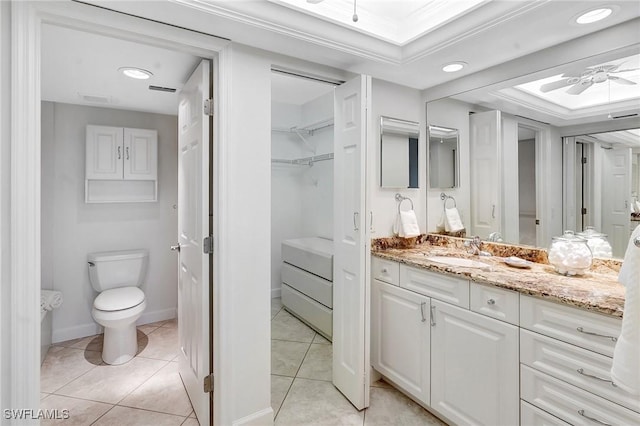 bathroom with tile patterned flooring, baseboards, ceiling fan, toilet, and vanity