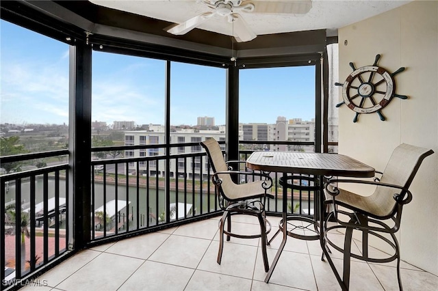 sunroom featuring plenty of natural light, a view of city, and ceiling fan