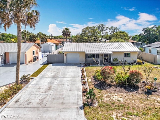 ranch-style house with stucco siding, an attached garage, metal roof, and fence