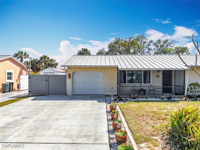 view of front of house featuring stucco siding, a front lawn, driveway, a gate, and a garage