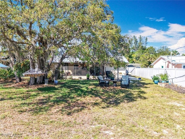 view of yard featuring a sunroom and fence