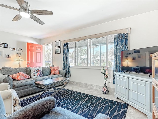 living room featuring a ceiling fan and a wealth of natural light