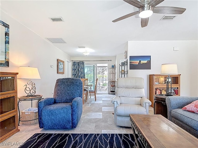 living room featuring visible vents, a ceiling fan, and stone finish floor