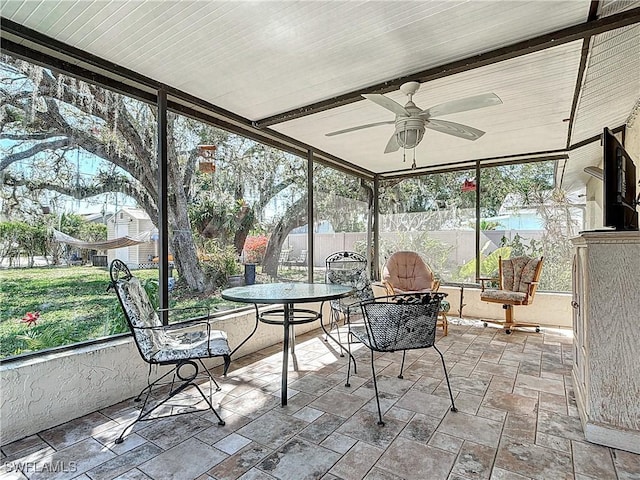 unfurnished sunroom with ceiling fan