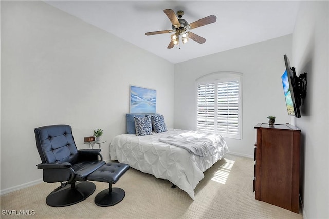 bedroom featuring baseboards, light colored carpet, and ceiling fan