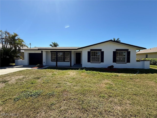 single story home with a garage, a front yard, driveway, and stucco siding