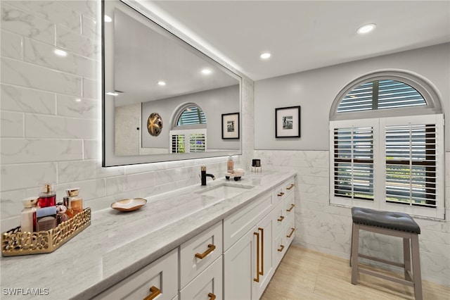 bathroom with vanity, tile walls, and recessed lighting