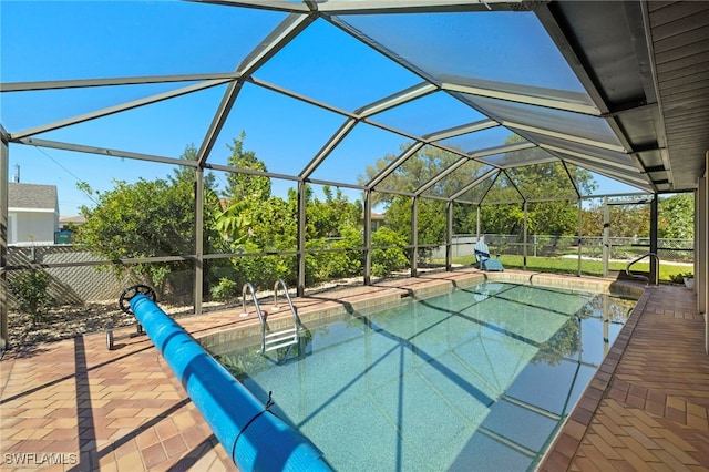 view of pool with a patio area, a lanai, and fence