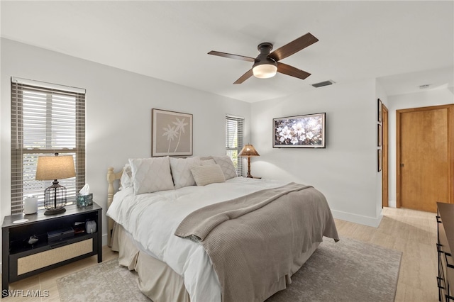 bedroom with visible vents, baseboards, light wood-type flooring, and ceiling fan