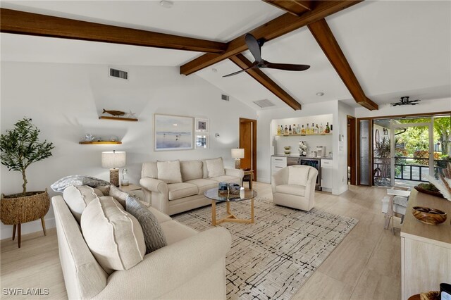 living area featuring visible vents, beverage cooler, lofted ceiling with beams, a bar, and light wood finished floors