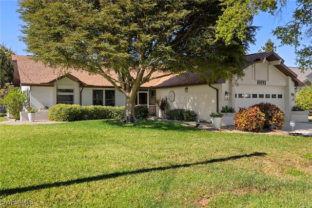 ranch-style house with stucco siding, an attached garage, and a front lawn