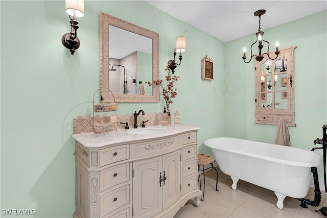 full bath featuring tile patterned floors, a notable chandelier, a shower stall, a freestanding bath, and vanity