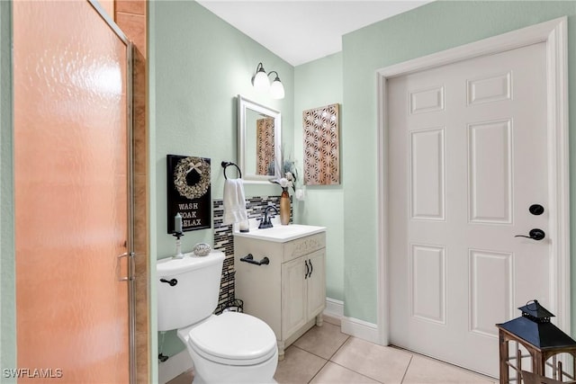 bathroom featuring baseboards, toilet, a stall shower, tile patterned floors, and vanity
