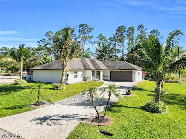 view of front of house with stucco siding, a front yard, decorative driveway, and a garage