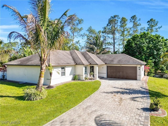 single story home featuring decorative driveway, a front lawn, an attached garage, and stucco siding