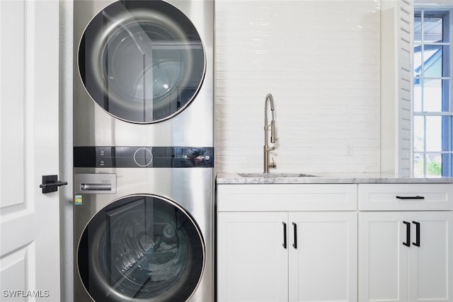 washroom featuring a sink, cabinet space, and stacked washer and dryer