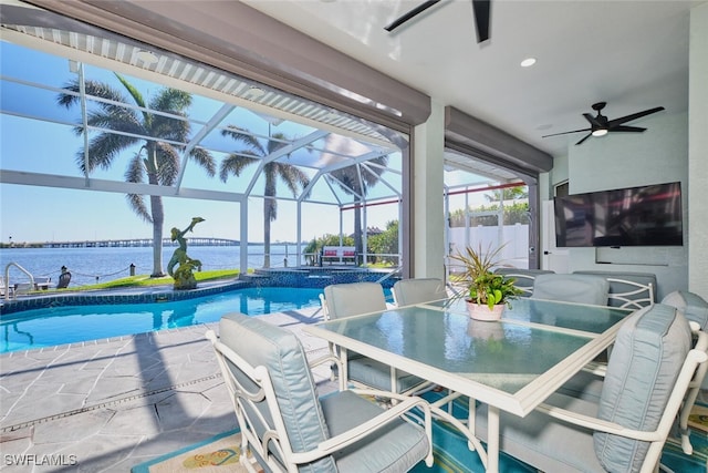 view of pool featuring outdoor dining space, a ceiling fan, a pool with connected hot tub, a lanai, and a patio area