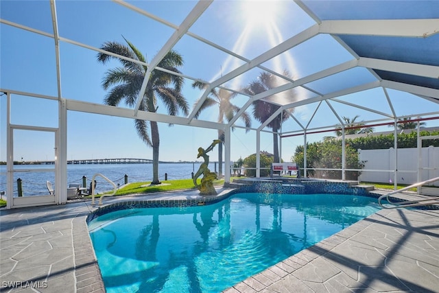 view of pool with a patio, a pool with connected hot tub, a lanai, and a water view