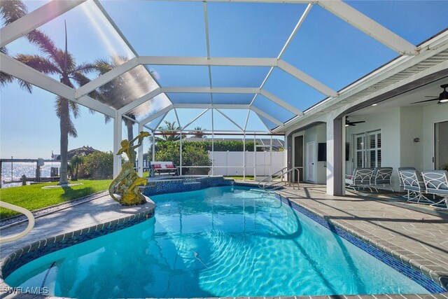 pool featuring glass enclosure, a patio, ceiling fan, and fence