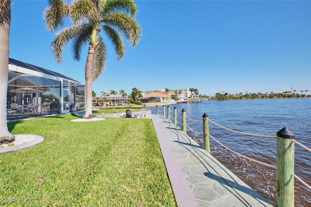 dock area featuring a lanai, a lawn, and a water view