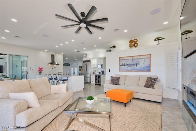 living room featuring recessed lighting, visible vents, a glass covered fireplace, and ceiling fan