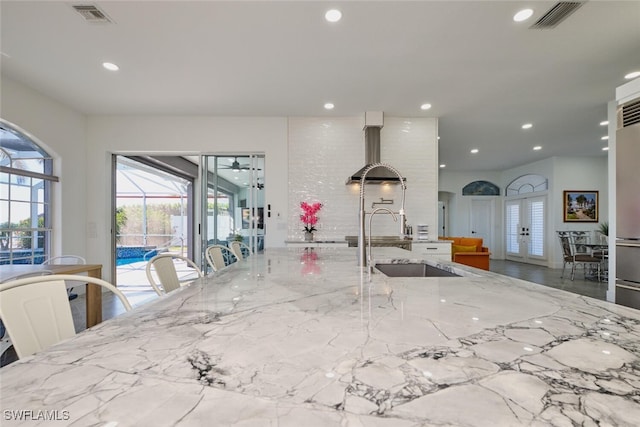 kitchen featuring recessed lighting, visible vents, light stone countertops, and a sink