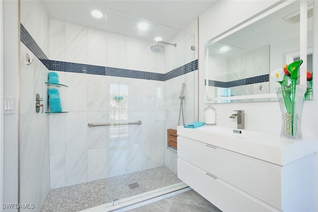 bathroom with visible vents, vanity, and a tile shower