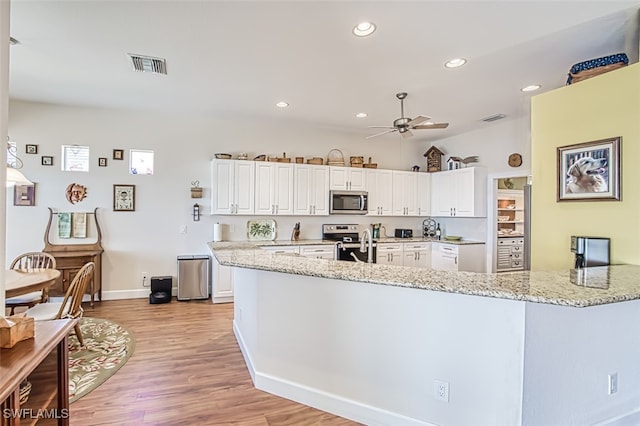 kitchen featuring visible vents, white cabinetry, and stainless steel appliances