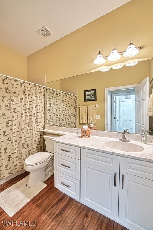 full bathroom with vanity, wood finished floors, visible vents, curtained shower, and toilet