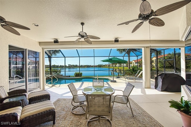 view of patio with a water view, a ceiling fan, a grill, an outdoor pool, and a lanai