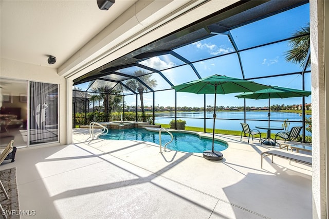 view of swimming pool with glass enclosure, a pool with connected hot tub, a patio, and a water view