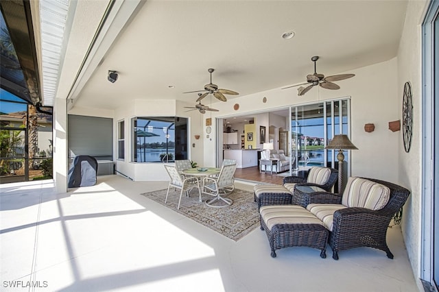 view of patio featuring glass enclosure, an outdoor hangout area, ceiling fan, and outdoor dining space