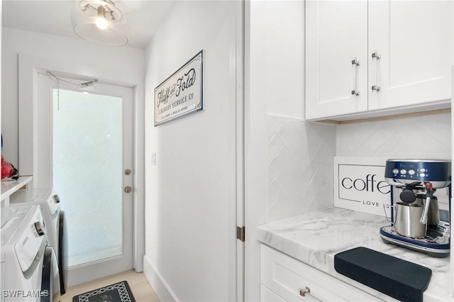 kitchen with light stone countertops, backsplash, independent washer and dryer, and white cabinets