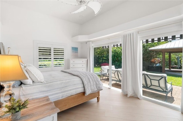 bedroom featuring wood finished floors, access to exterior, and a ceiling fan