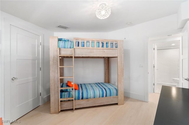 bedroom featuring visible vents, baseboards, and wood finished floors