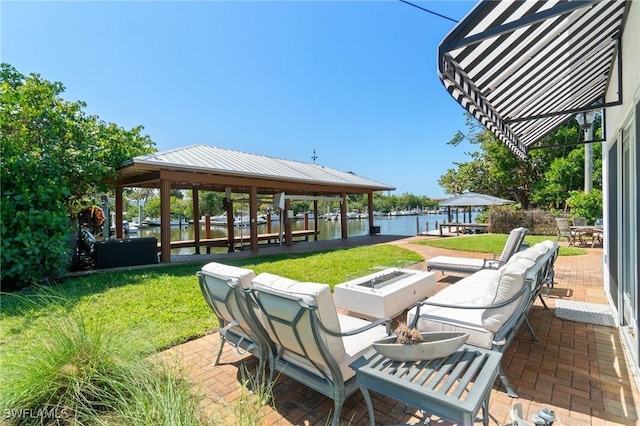 view of patio with an outdoor living space with a fire pit and a water view